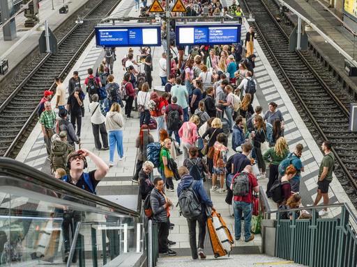 Viele Passagiere an einem Bahngleis ohne Zug.