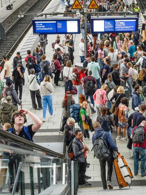 Viele Passagiere an einem Bahngleis ohne Zug.