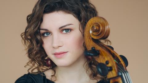 Porträtfoto von Julia Hagen, die ihr Violoncello nah an ihr Gesicht herangelassen hat.