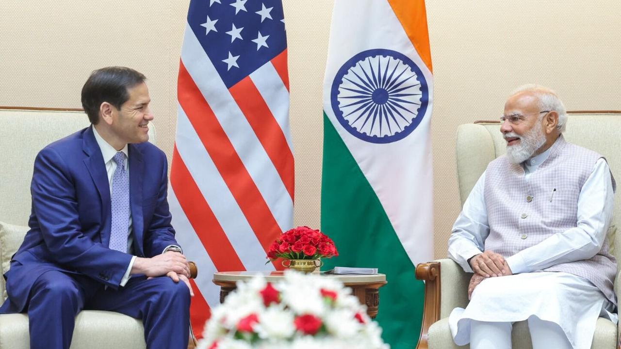 US-Außenminister Rubio und Indiens Permierminister Modi sitzen auf zwei Sesseln und schauen sich im an. Im Hintergrund stehen die Flaggen der USA und Indiens.