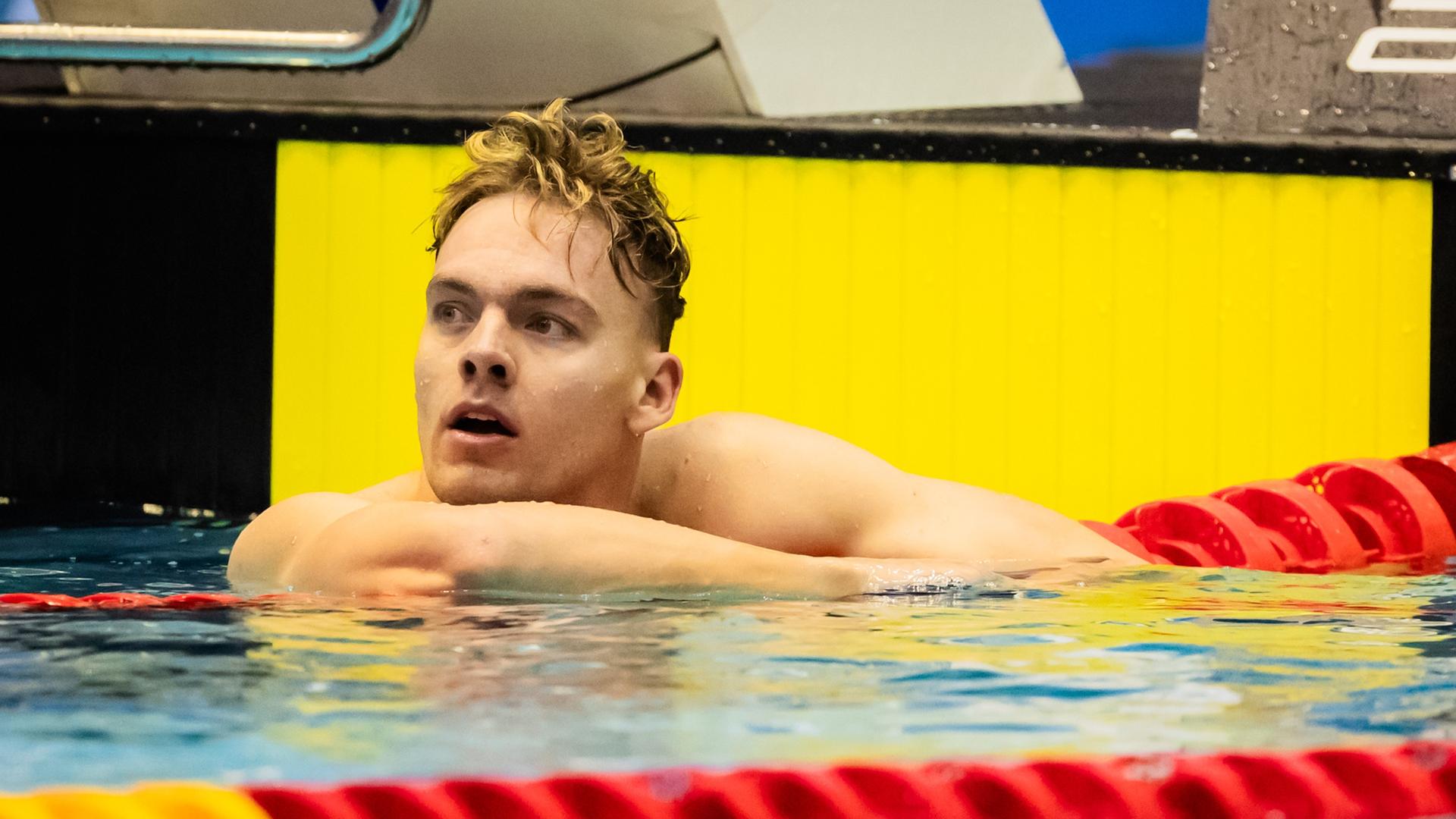Josha Salchow lehnt im Schwimmbecken über einer Bahnabtrennung.
