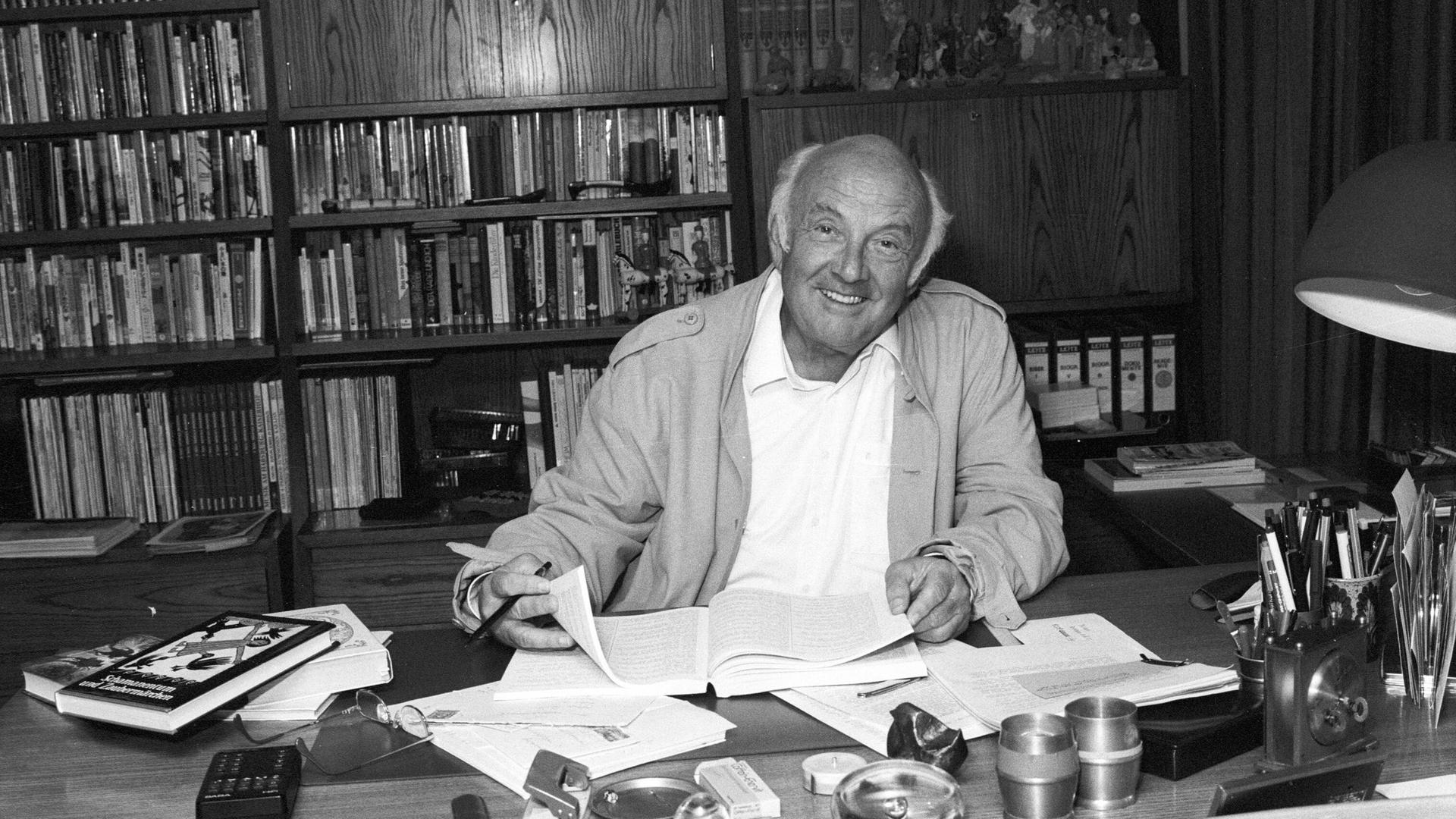 Kinderbuchautor Otfried Preußler sitzend am Schreibtisch in seinem Arbeitszimmer. Schwarz-weiß Aufnahme von 1988.