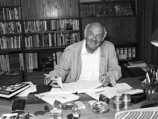 Kinderbuchautor Otfried Preußler sitzend am Schreibtisch in seinem Arbeitszimmer. Schwarz-weiß Aufnahme von 1988.
