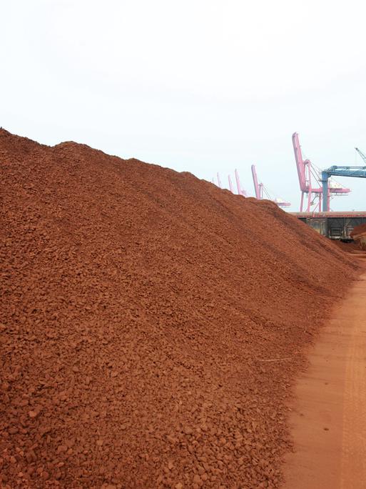 Ein Radlader im Hafen von Lianyungang in der ostchinesischen Provinz Jiangsu häuft große Mengen von Seltenen Erden zu einem weitläufigen Materialberg auf einem Hafengelände auf.
