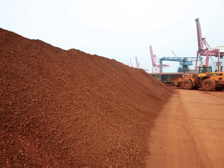 Ein Radlader im Hafen von Lianyungang in der ostchinesischen Provinz Jiangsu häuft große Mengen von Seltenen Erden zu einem weitläufigen Materialberg auf einem Hafengelände auf.