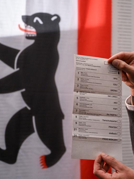 Ein Mann hält den Stimmzettel für die Erststimme in den Händen. Zum Beginn der Briefwahl für die Berliner Wiederholungswahlen am 12. Februar werden bei einem Pressetermin im Rathaus Zehlendorf die Vorbereitungen vorgestellt.