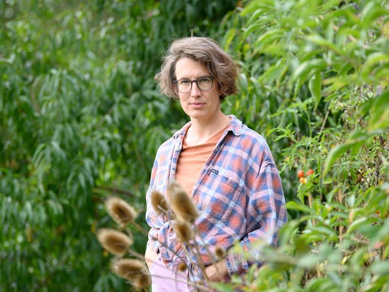 Die Autorin und Filmemacherin Lola Randl steht in ihrem Garten. Die Autorin und Filmemacherin Lola Randl steht in ihrem Garten.