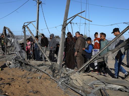 Nach einem Bombenangriff versammeln sich Passanten um die Überreste eines zerstörten Hauses in Rafah, Gaza, 14. März 2024.