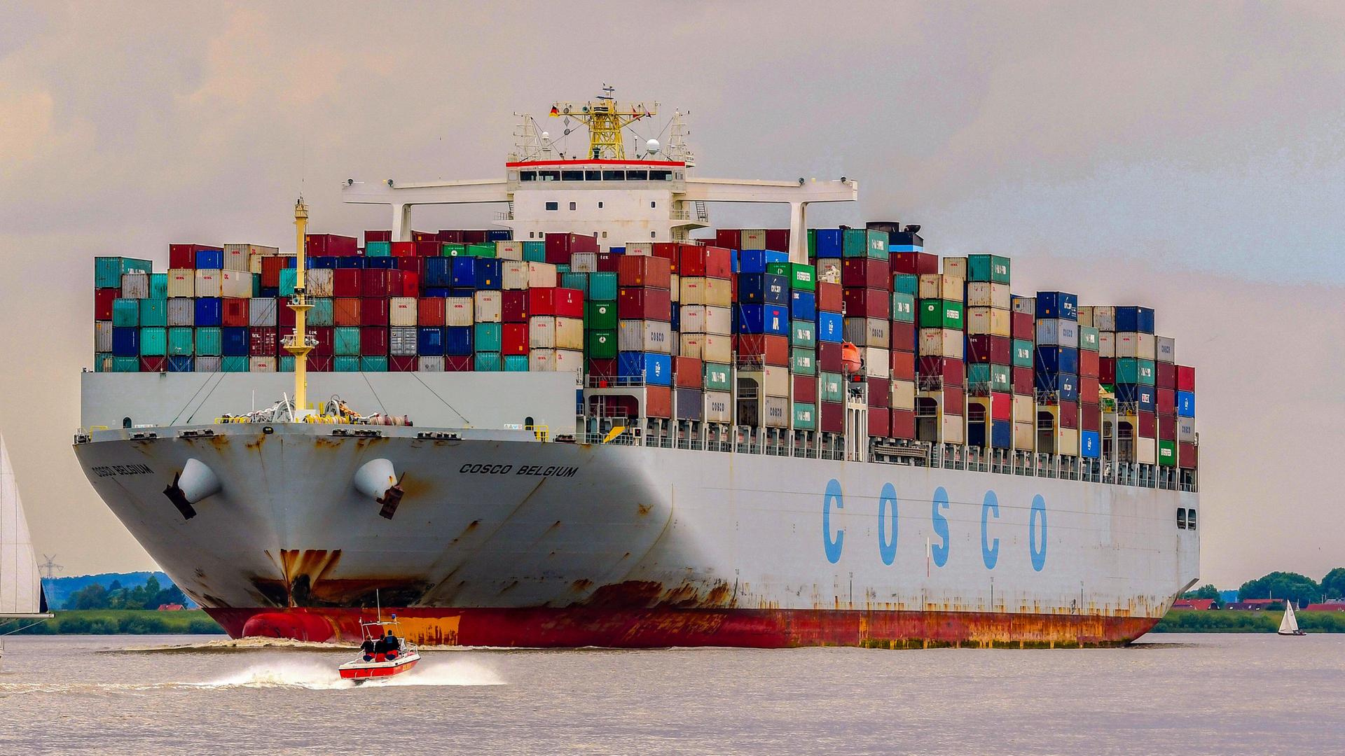 Ein Containerschiff des chinesischen Staatskonzerns Cosco fährt mit voller Ladung elbaufwärts in den Containerhafen in Hamburg. Ein Containerschiff des chinesischen Staatskonzerns Cosco fährt mit voller Ladung elbaufwärts in den Containerhafen in Hamburg.