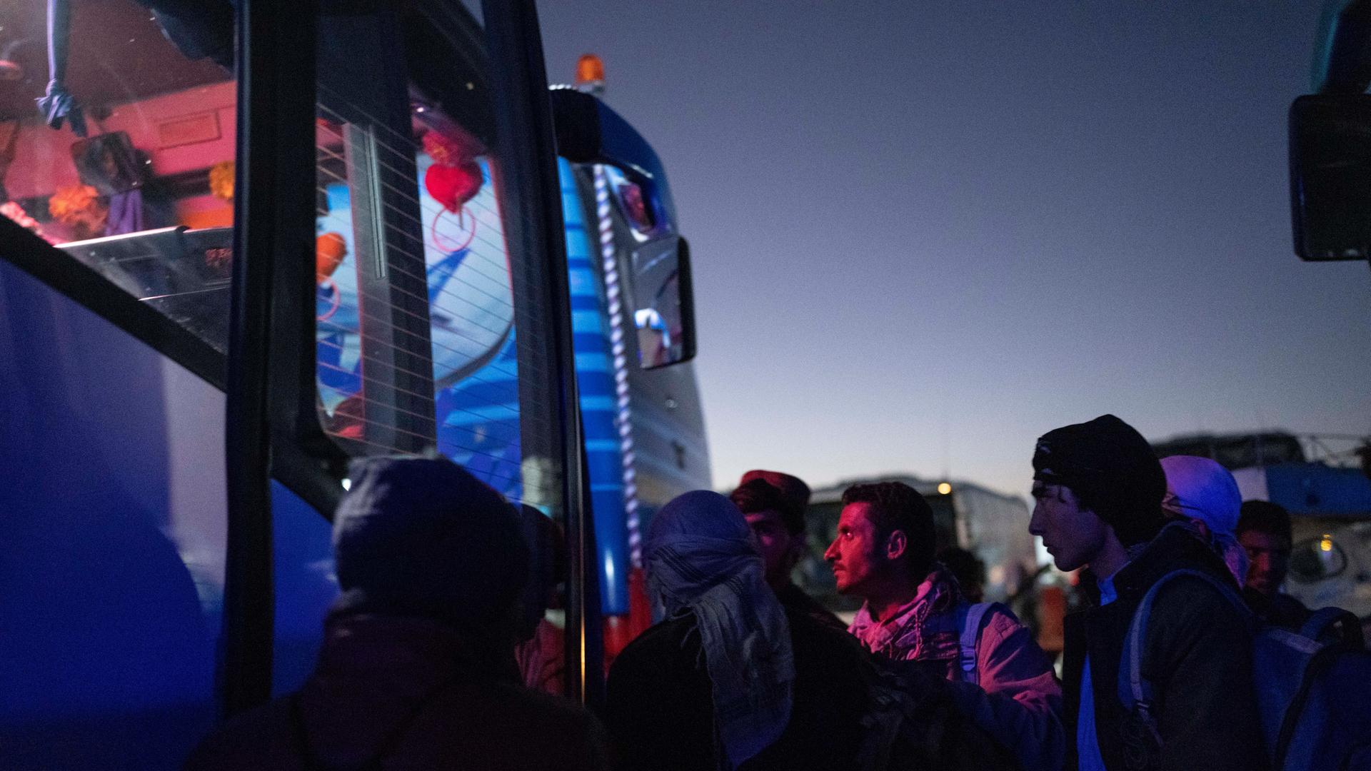 Afghanische Männer besteigen einen Bus in Herat, um nach Nimrus nahe der iranischen Grenze zu fahren. 