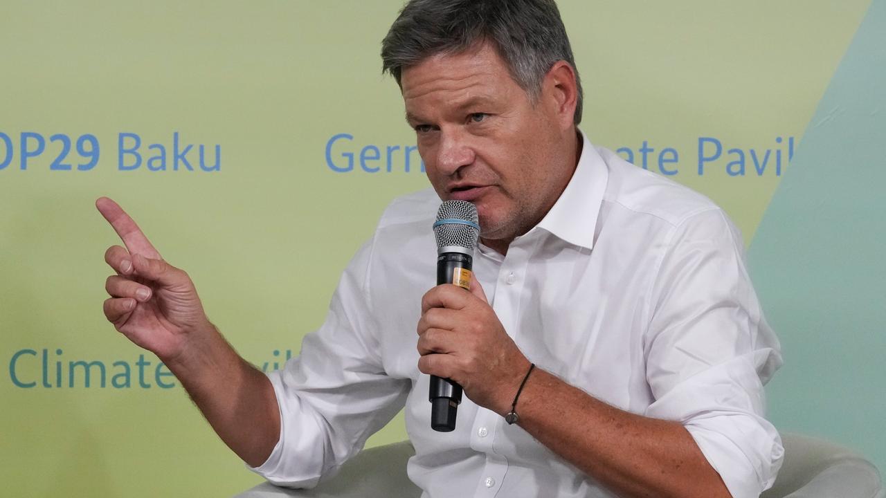 Robert Habeck spricht in ein Mikrofon, im Hintergrund ist eine Tafel mit der Aufschrift Climate Pavilion COP29.