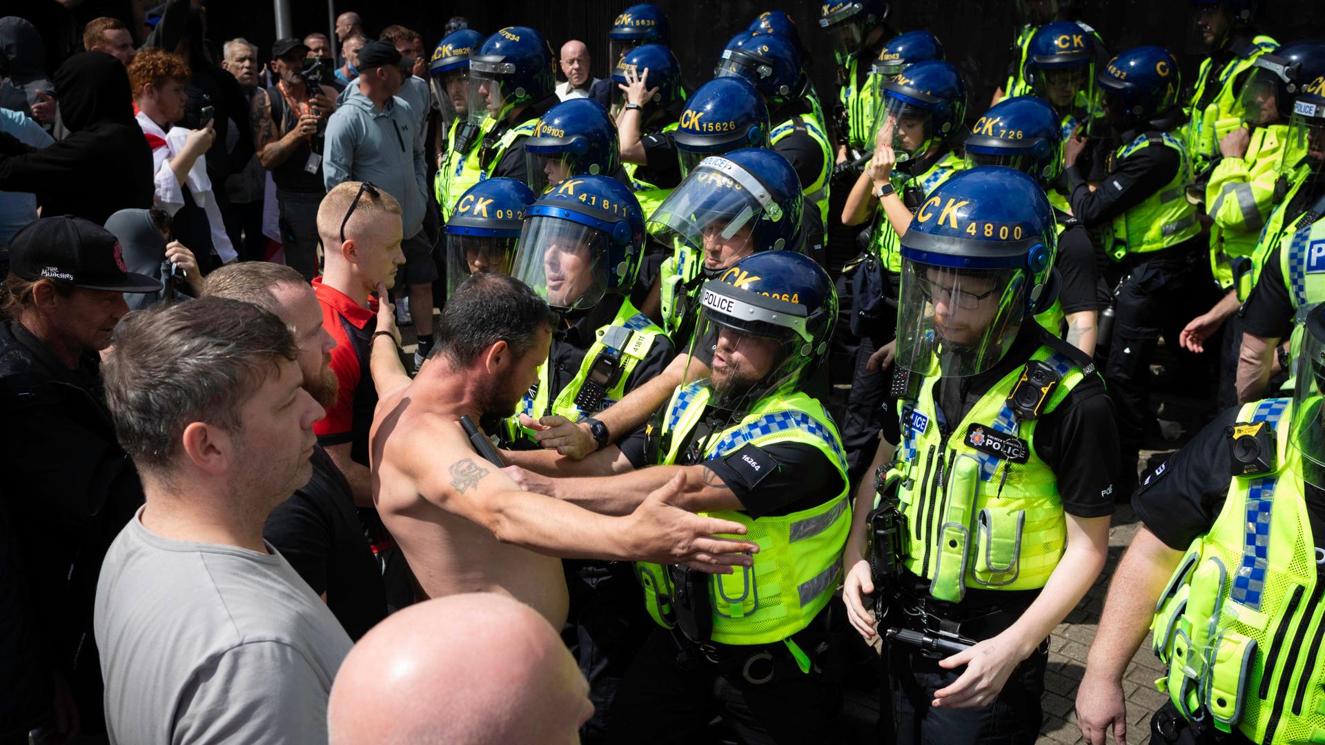 Ein Einwanderungsgegner stellt sich der Bereitschaftspolizei, nachdem es in den Piccadilly Gardens während einer Stand Up To Racism Unity-Kundgebung gegen Einwanderungsgegner zu Handgreiflichkeiten gekommen war.