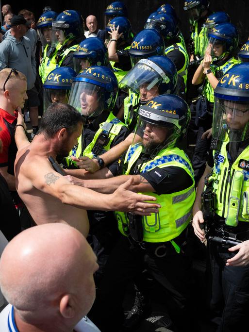 Ein Einwanderungsgegner stellt sich der Bereitschaftspolizei, nachdem es in den Piccadilly Gardens während einer Stand Up To Racism Unity-Kundgebung gegen Einwanderungsgegner zu Handgreiflichkeiten gekommen war.