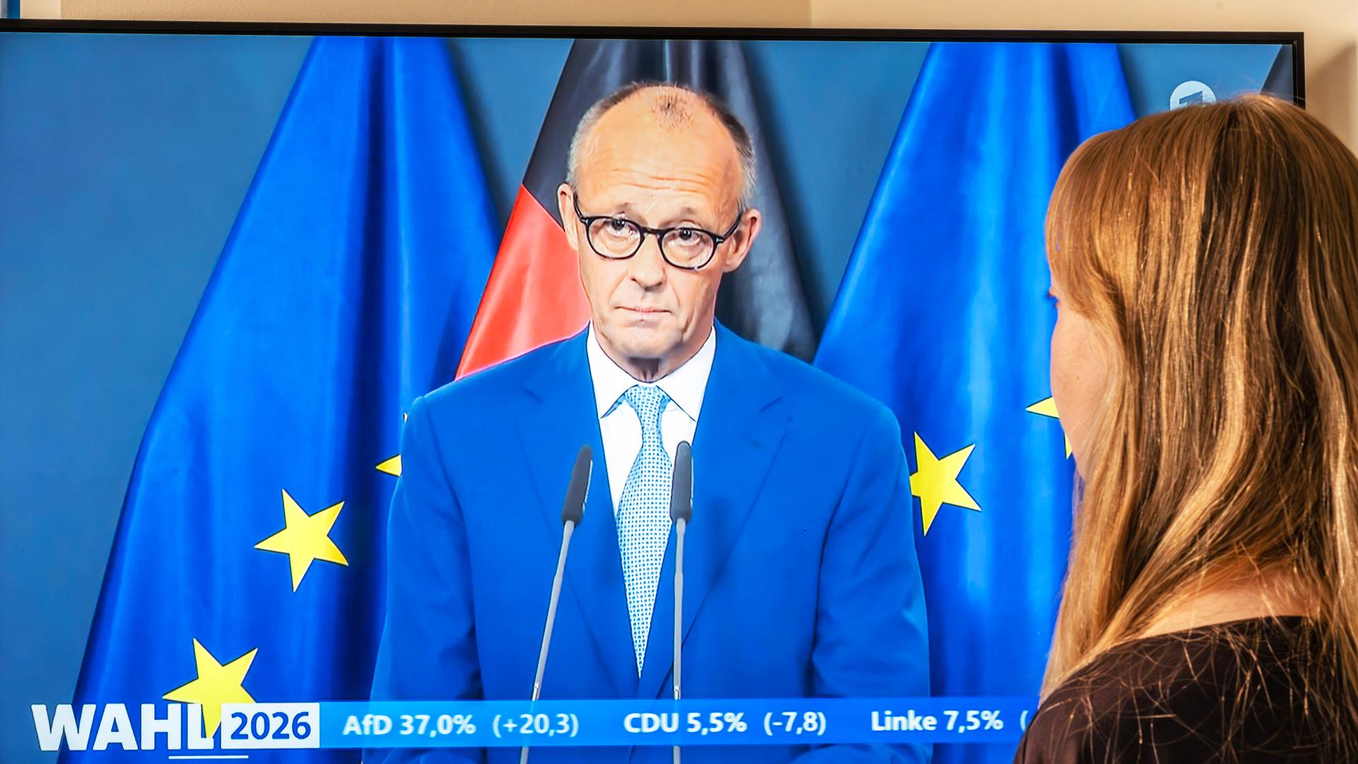 TV-Zuschauerin vor einem Fernsehgerät daheim: Rede von Bundeskanzler Friedrich Merz nach den ersten Prognosen zu den Landtagswahlen in Berlin und Mecklenburg-Vorpommern.