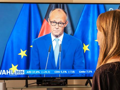 TV-Zuschauerin vor einem Fernsehgerät daheim: Rede von Bundeskanzler Friedrich Merz nach den ersten Prognosen zu den Landtagswahlen in Berlin und Mecklenburg-Vorpommern. TV-Zuschauerin vor einem Fernsehgerät daheim: Rede von Bundeskanzler Friedrich Merz nach den ersten Prognosen zu den Landtagswahlen in Berlin und Mecklenburg-Vorpommern.