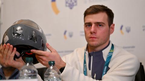 Der Skeletonpilot Wladislaw Heraskewytsch (Ukraine) zeigt bei einer Pressekonferenz im ukrainischen Konsulat in Mailand seinen Helm mit Fotos von ukrainischen Sportlern, die im russischen Angriffskrieg getötet wurden.