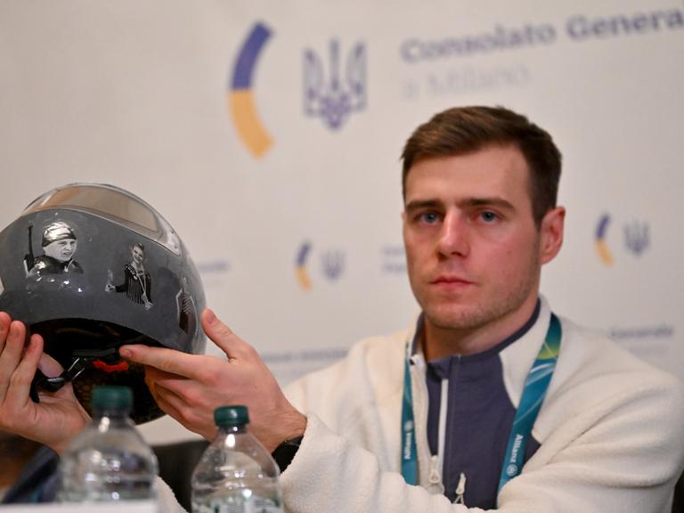 Der Skeletonpilot Wladislaw Heraskewytsch (Ukraine) zeigt bei einer Pressekonferenz im ukrainischen Konsulat in Mailand seinen Helm mit Fotos von ukrainischen Sportlern, die im russischen Angriffskrieg getötet wurden.