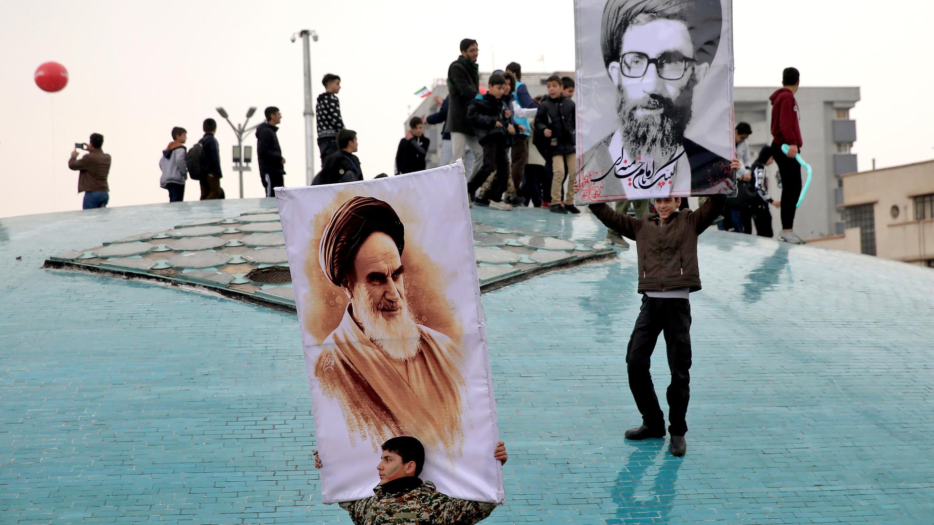 Ein Junge in Teheran hält ein großes Bild von Revolutionsführer Chomeini hoch.