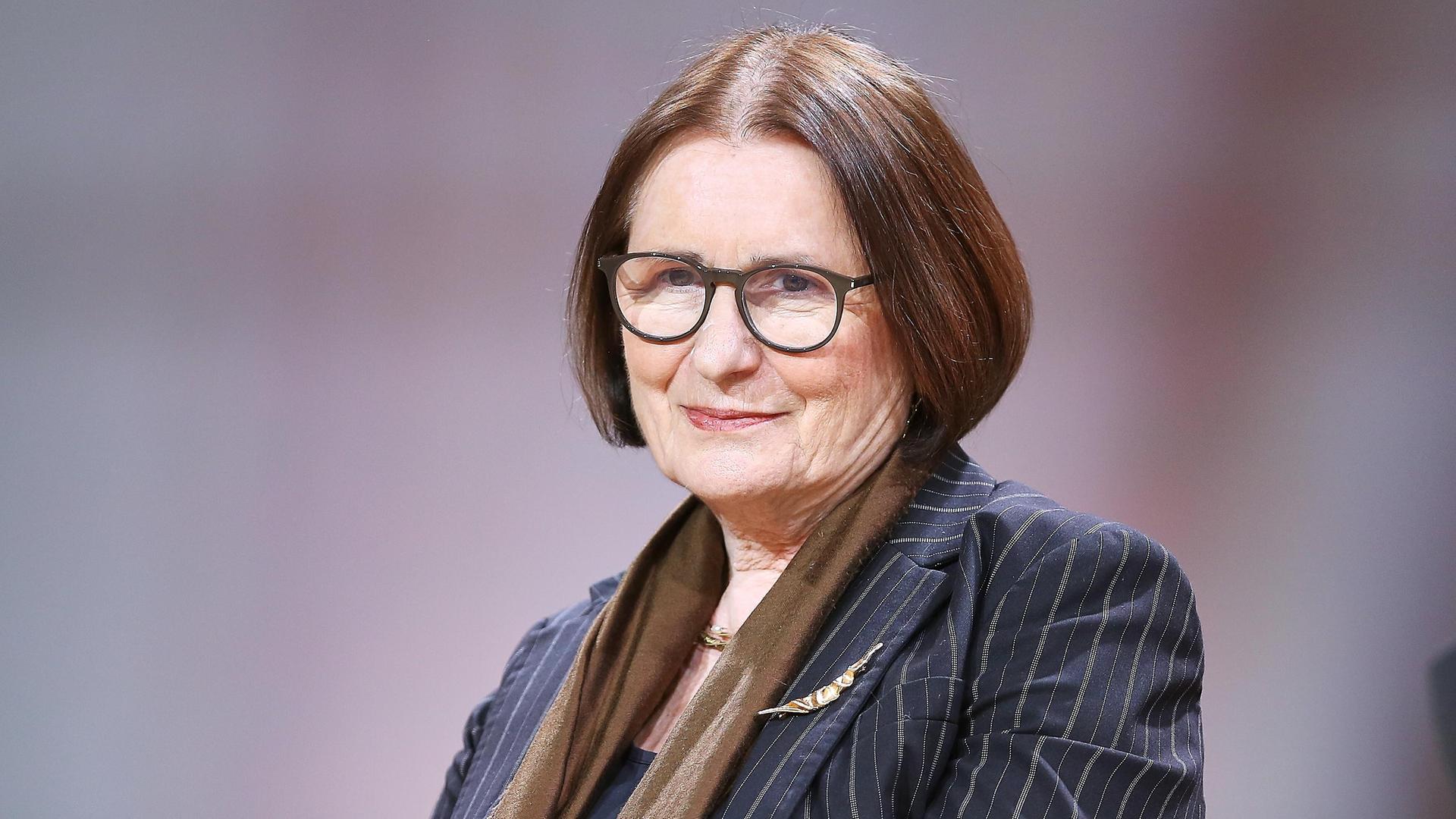 Irina Scherbakowa posiert mit Brille und Nadelstreifen-Blazer auf einem Podium der Frankfurter Buchmesse für ein Pressefoto. Irina Scherbakowa posiert mit Brille und Nadelstreifen-Blazer auf einem Podium der Frankfurter Buchmesse für ein Pressefoto.