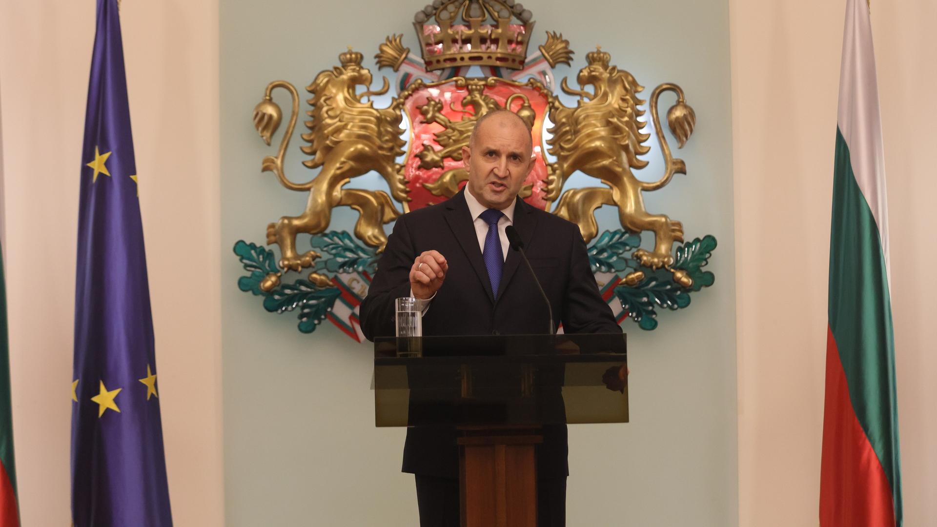 Bulgariens Präsident Rumen Radew kündigt seinen Rücktritt vom Amt des Staatspräsidenten an. Dabei steht er an einem Rednerpult, zu seiner linken Seite eine Europa-Flagge, zu seiner rechten Seite eine bulgarische.