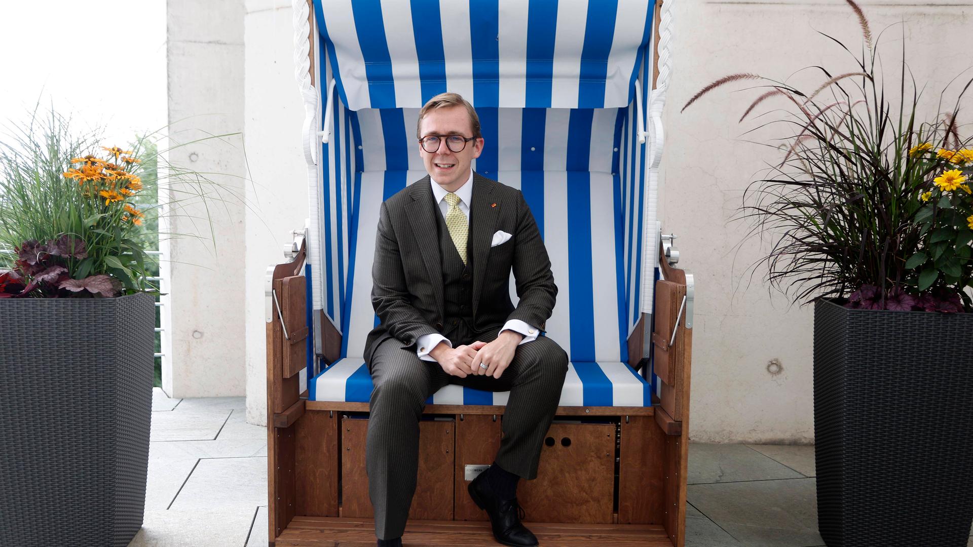 Porträt von Philipp Amthor Er sitzt in einem Strandkorb aus Mecklenburg-Vorpommern auf dem Balkon seines Büro im Bundeskanzleramt.