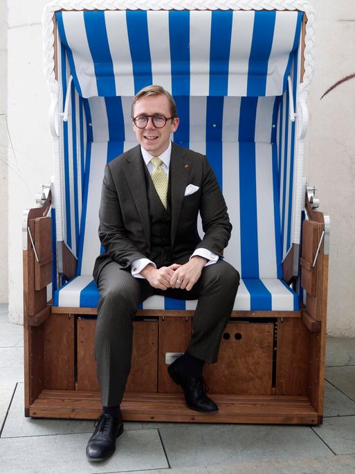Porträt von Philipp Amthor Er sitzt in einem Strandkorb aus Mecklenburg-Vorpommern auf dem Balkon seines Büro im Bundeskanzleramt.
