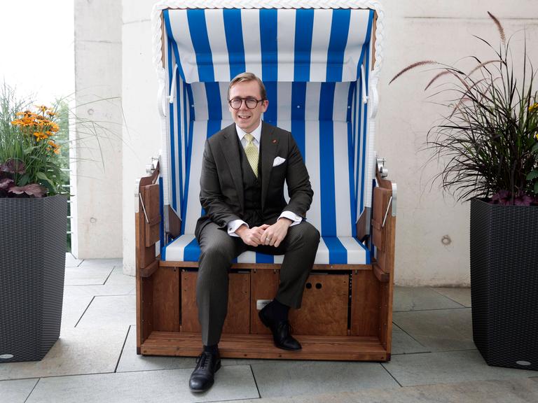 Porträt von Philipp Amthor Er sitzt in einem Strandkorb aus Mecklenburg-Vorpommern auf dem Balkon seines Büro im Bundeskanzleramt.