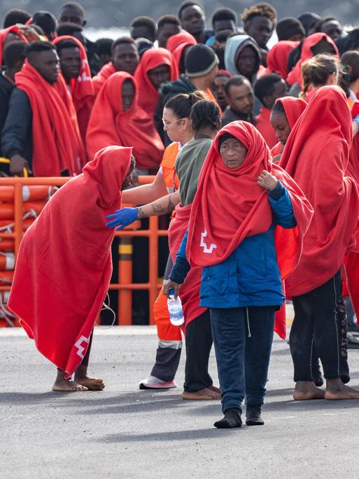 Ein Gruppe Flüchtlinge, eingehüllt in roten Decken, erreicht Arrecife auf Lanzarote.