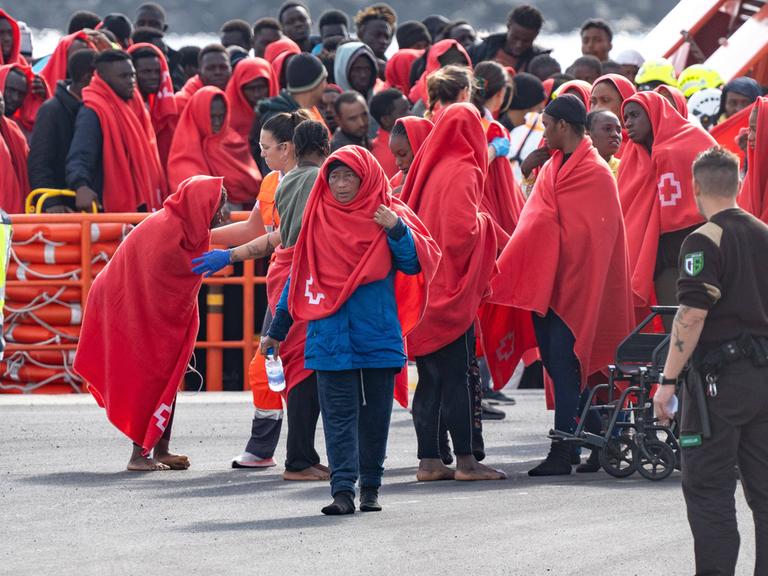 Ein Gruppe Flüchtlinge, eingehüllt in roten Decken, erreicht Arrecife auf Lanzarote.