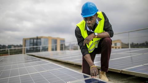 Ein Mitarbeiter prüft Solarpanels auf dem Dach einer Ausbildungseinrichtung für Solartechniker und Energieauditoren an der Strathmore University, Nairobi.