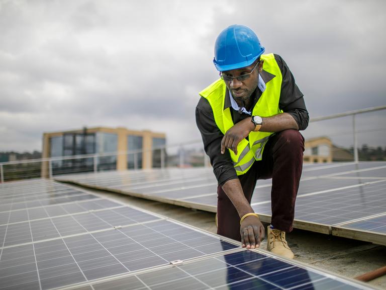 Ein Mitarbeiter prüft Solarpanels auf dem Dach einer Ausbildungseinrichtung für Solartechniker und Energieauditoren an der Strathmore University, Nairobi.