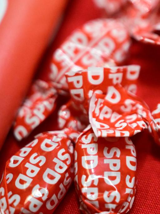 Das Logo der SPD ist auf mehreren roten Bonbons aufgedruckt. Das Logo der SPD ist auf mehreren roten Bonbons aufgedruckt.