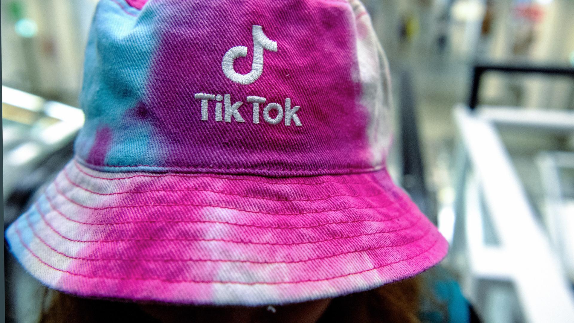 Eine Frau trägt am einen Hut mit dem Logo der Social Media Plattform Tik-Tok.