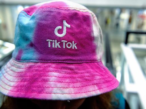 Eine Frau trägt am einen Hut mit dem Logo der Social Media Plattform Tik-Tok.