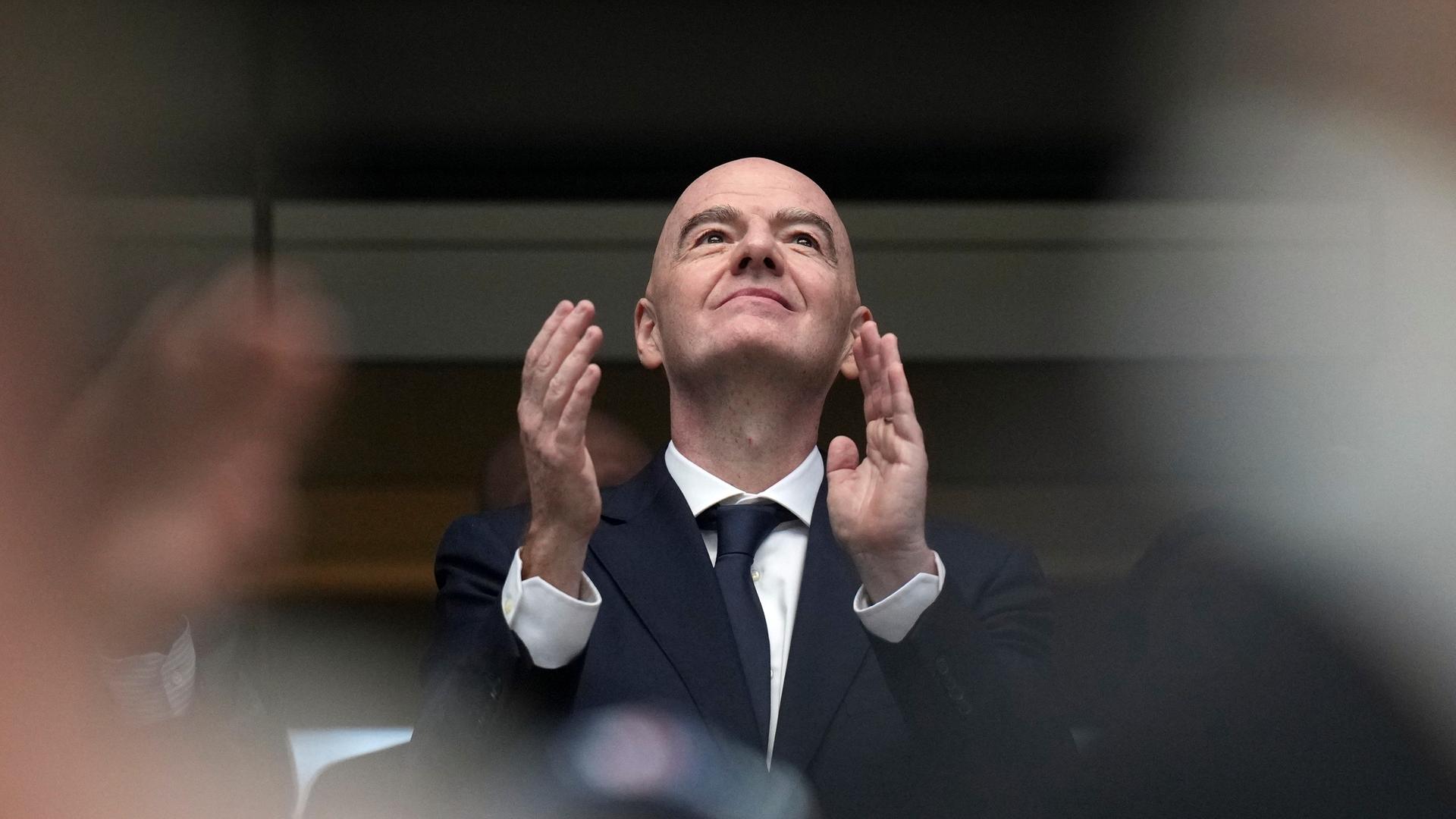  FIFA-Präsident Gianni Infantino sitzt bei der WM in den USA im Stadion und klatscht in die Hände. Er schaut nach oben. 