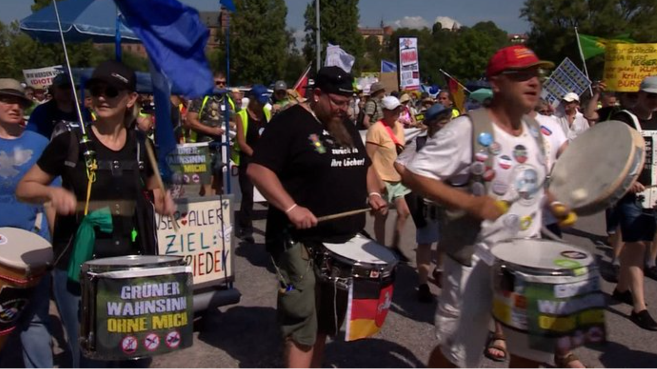 Teilnehmer des Protestzugs mit Trommeln, Plakaten und Fahnen in den Händen. Teilnehmer des Protestzugs mit Trommeln, Plakaten und Fahnen in den Händen.