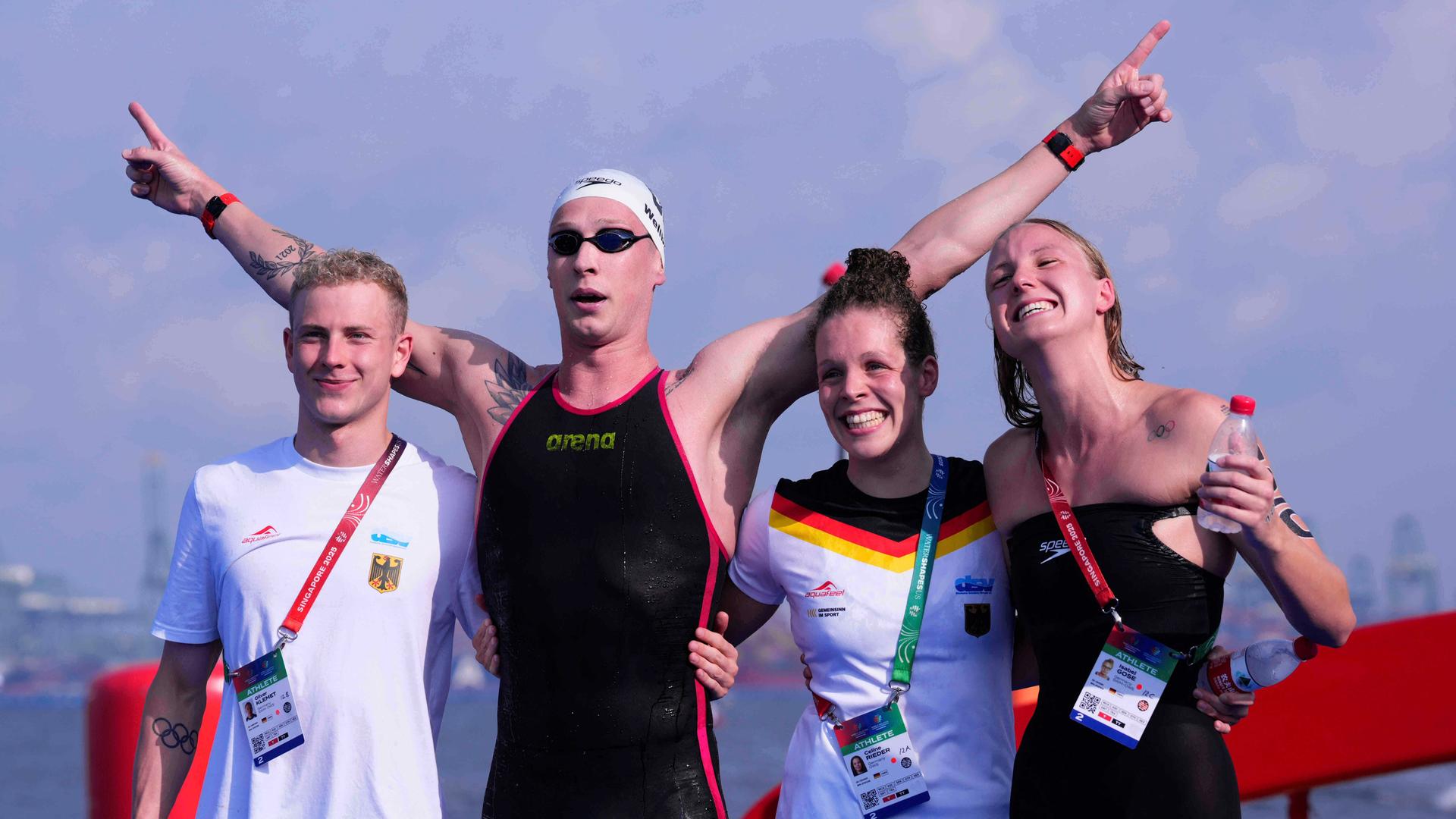 Florian Wellbrock freut sich über seine 4. Gold-Medaille mit der Staffel. Neben ihm stehen die Schwimmer Oliver Klemet (links) Isabel Gose und Celine Rieder. Er hat noch seine Schwimmbrille auf. Florian Wellbrock freut sich über seine 4. Gold-Medaille mit der Staffel. Neben ihm stehen die Schwimmer Oliver Klemet (links) Isabel Gose und Celine Rieder. Er hat noch seine Schwimmbrille auf.