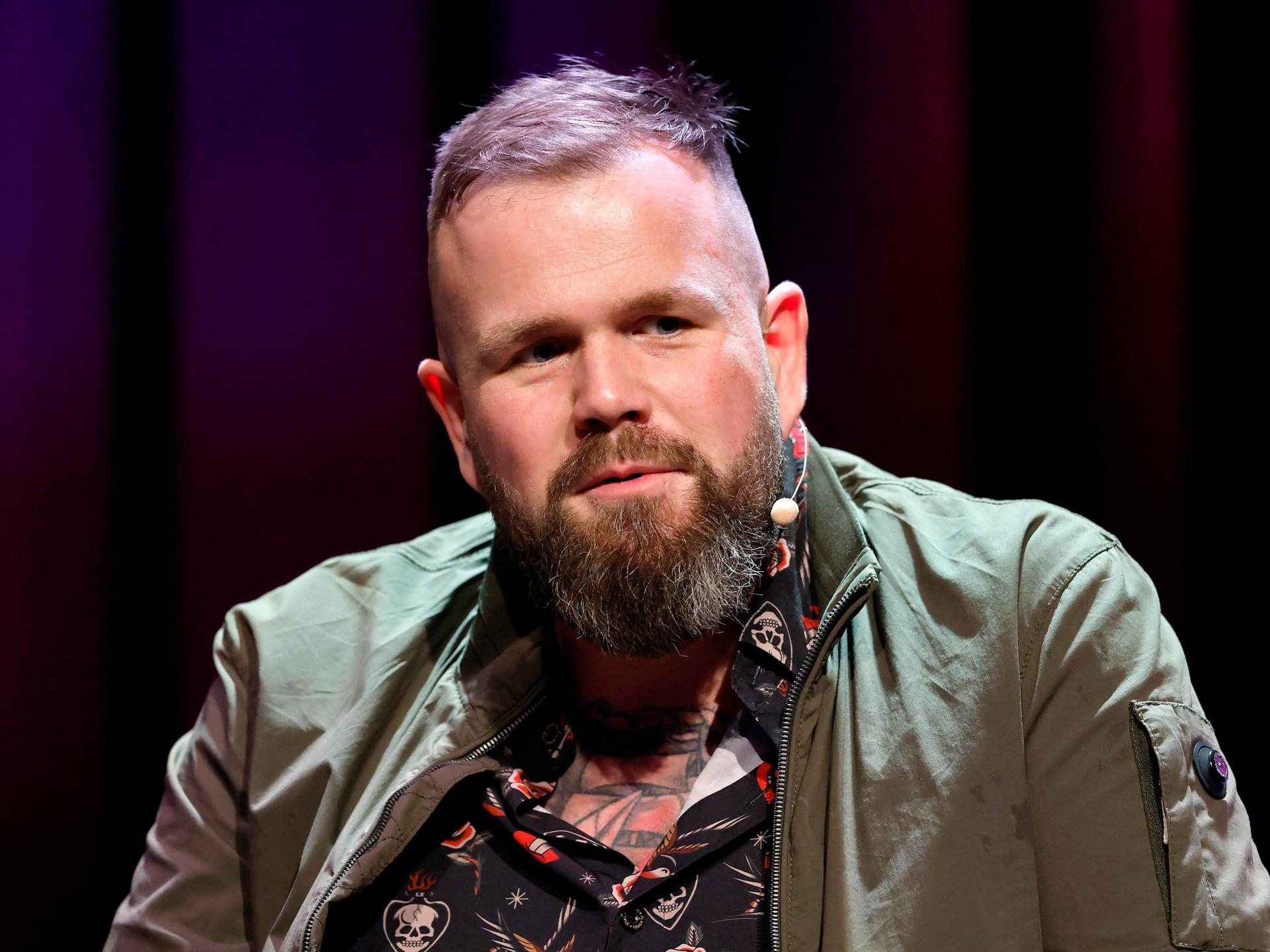 Sänger Jan Gorkow von der Band Feine Sahne Fischfilet sitzt bei einer Veranstaltung im Rahmen der Lit.Cologne 2026 im Theater am Tanzbrunnen vor einem dunklen Hintergrund auf der Bühne. Sänger Jan Gorkow von der Band Feine Sahne Fischfilet sitzt bei einer Veranstaltung im Rahmen der Lit.Cologne 2026 im Theater am Tanzbrunnen vor einem dunklen Hintergrund auf der Bühne.