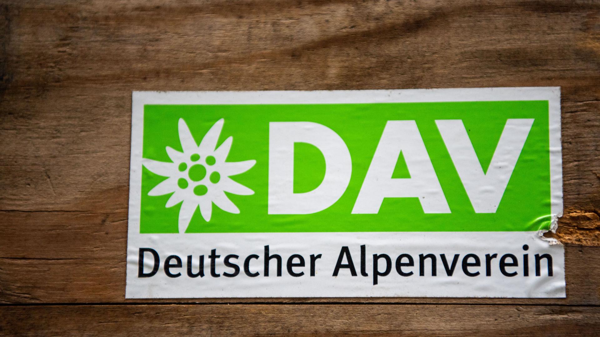 Das Logo des Deutschen Alpenverein (DAV) klebt auf einer Holzbox.