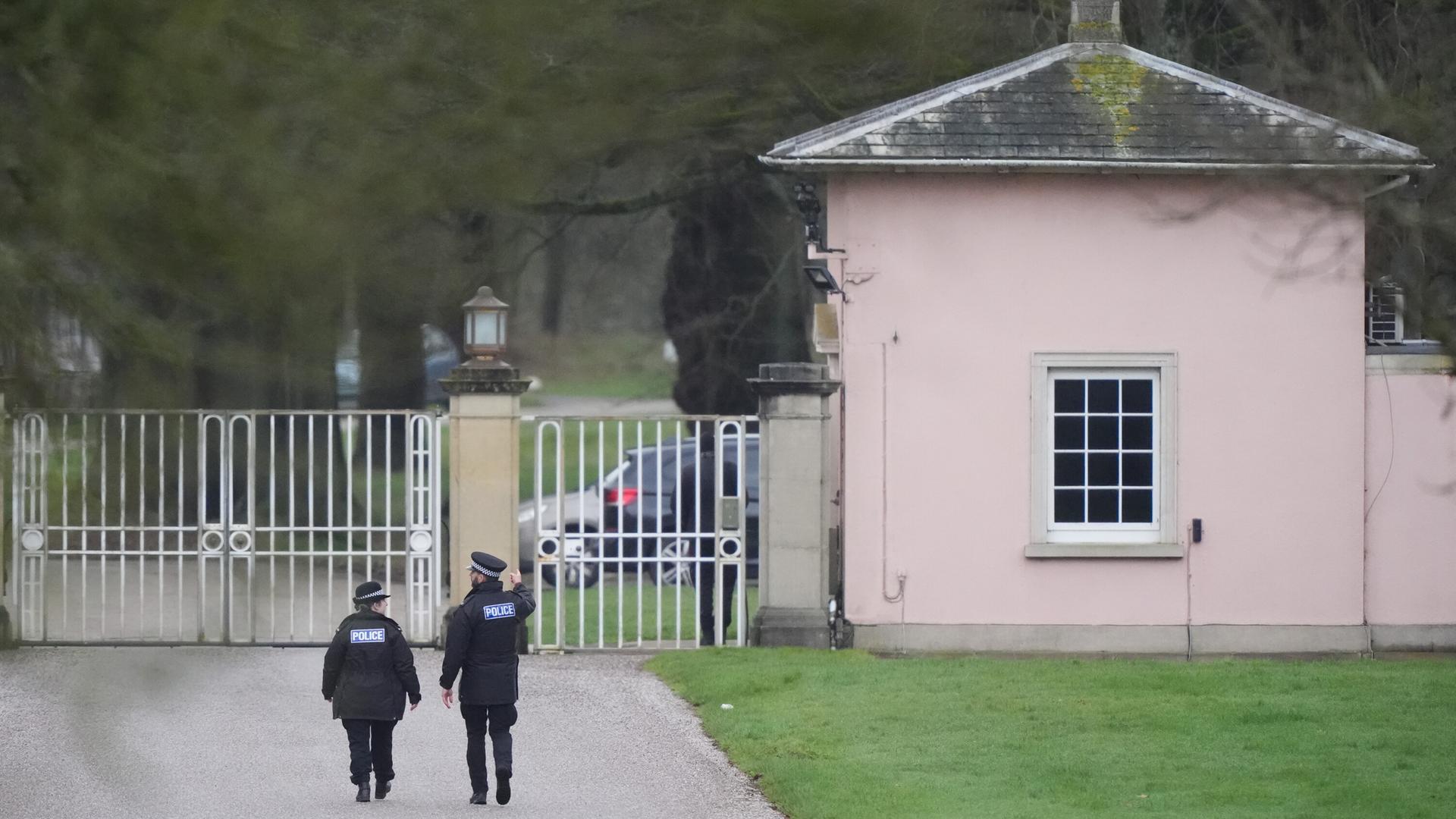 Polizisten laufen einen Weg zu einem Tor.