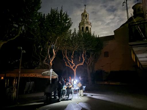 Auf der Placa de l'Ajuntament sitzen die Gäste eines Straßencafés in der Kleinstadt Premià de Mar bei Barcelona an der Kirche "San Cristòfol" bei einem Stromausfall im Licht von Taschenlampen und trinken lauwarmes Bier. 