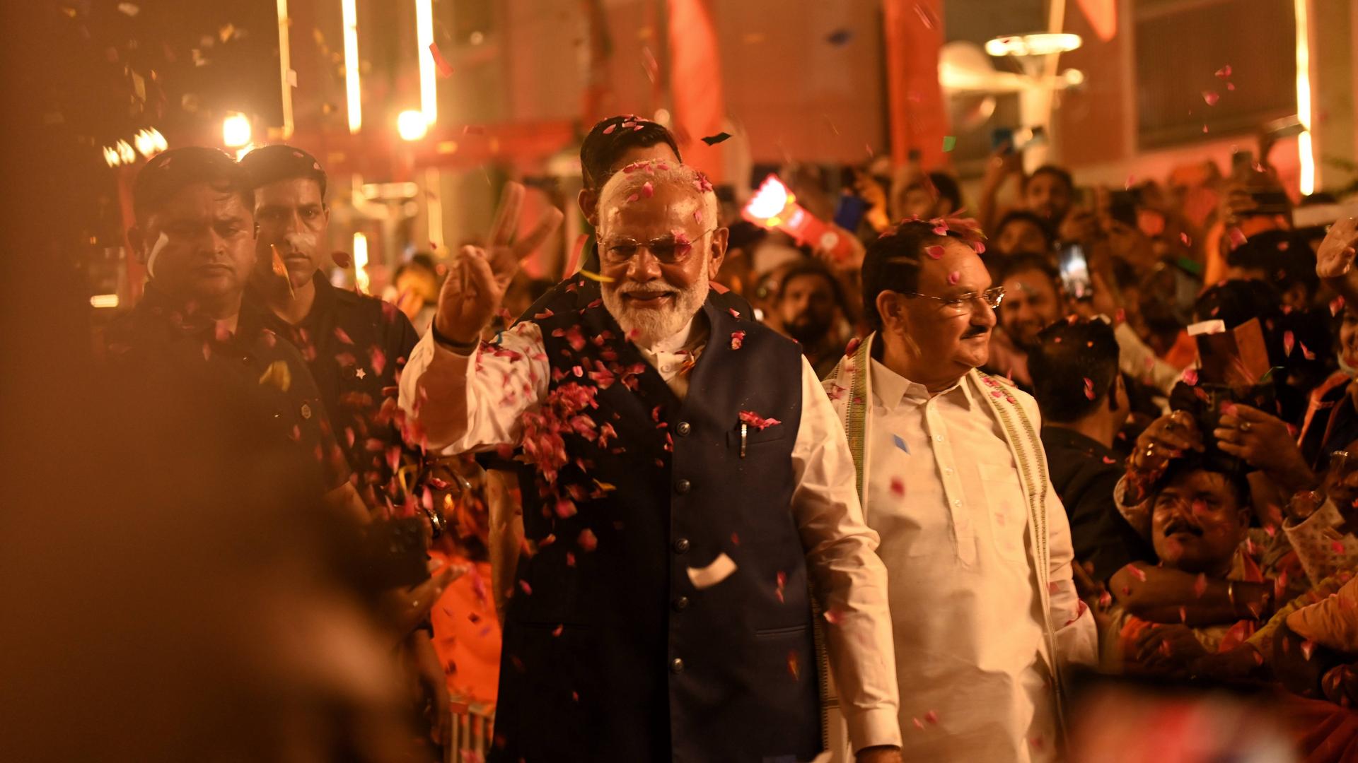 Der indische Premierminister Modi wird in Neu Delhi von seinen Anhängern gefeiert. Er geht eine Straße entlang, am Rand stehen viele Menschen und jubeln.
      