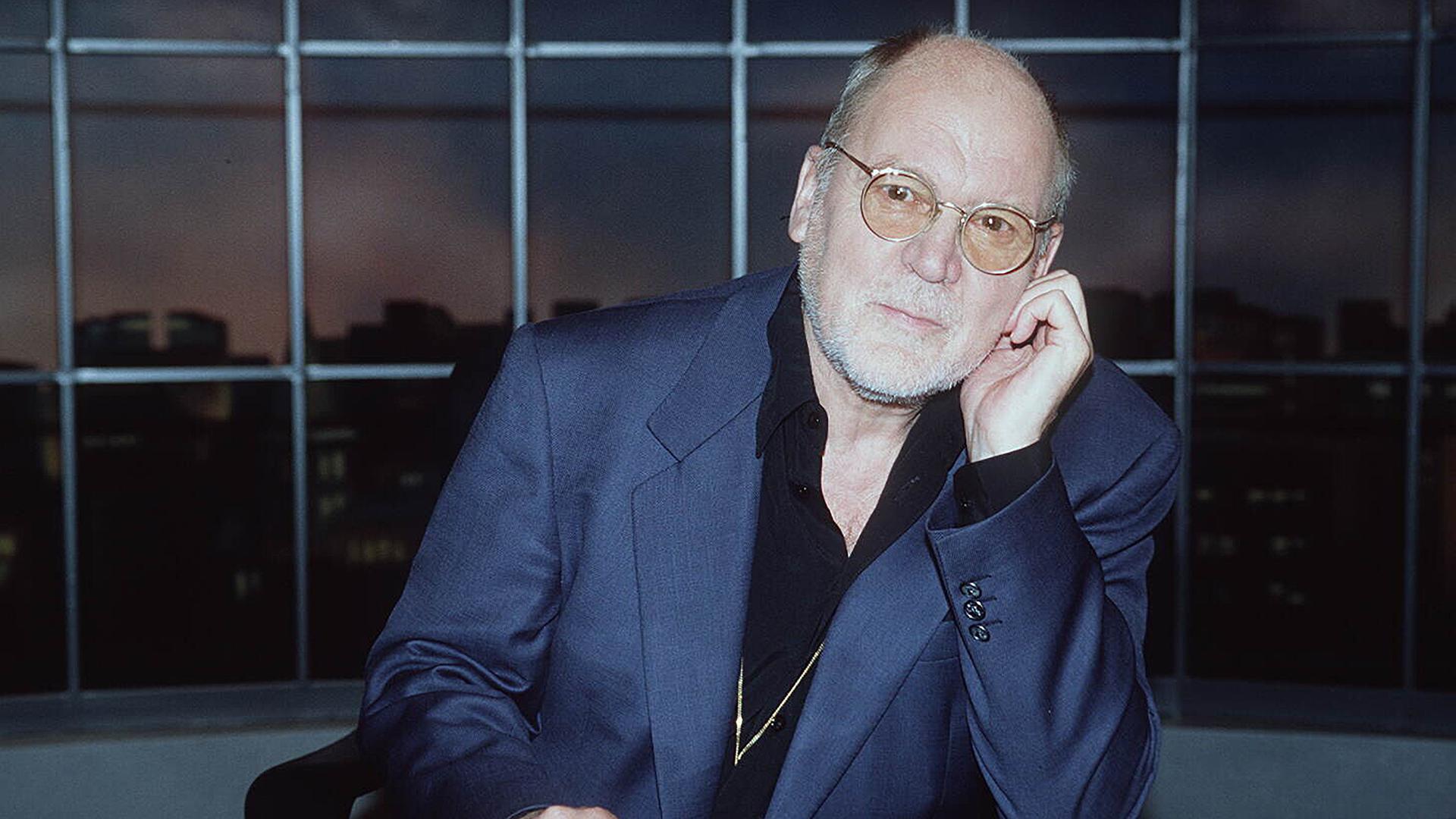 Hanns Dieter Hüsch 1995 aufgenommen, er sitzt an einem Tisch und schaut in die Kamera Hanns Dieter Hüsch 1995 aufgenommen, er sitzt an einem Tisch und schaut in die Kamera