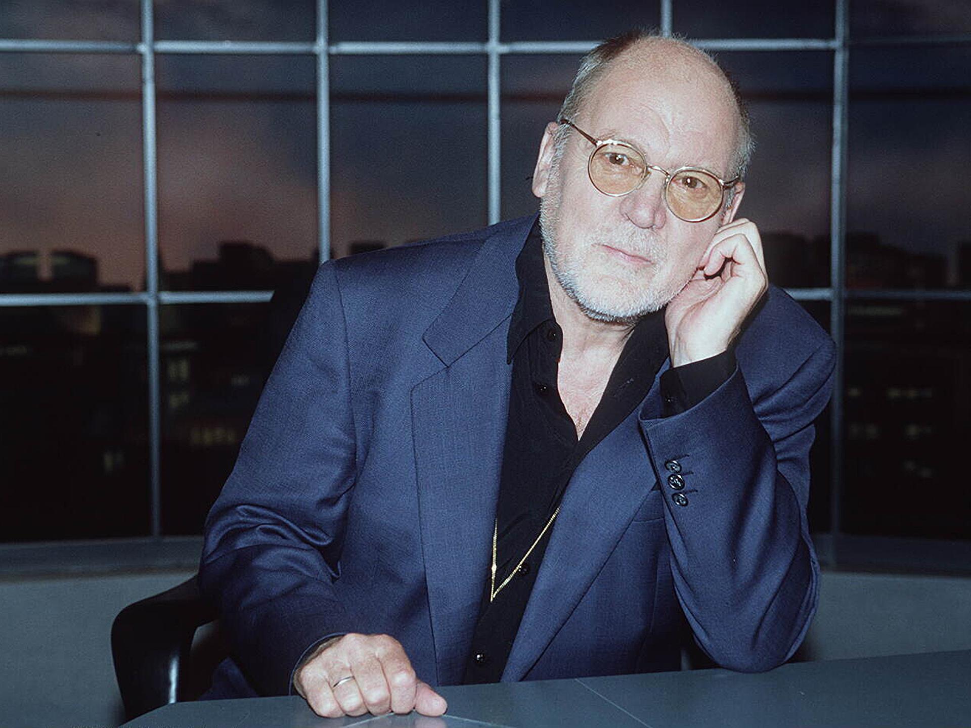 Hanns Dieter Hüsch 1995 aufgenommen, er sitzt an einem Tisch und schaut in die Kamera