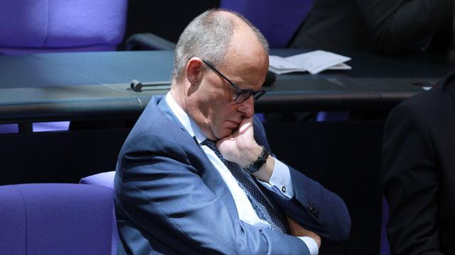 Der CDU-Politiker Friedrich Merz im Bundestag. Er hat das Gesicht auf die Hand gestützt und die Augen geschlossen.