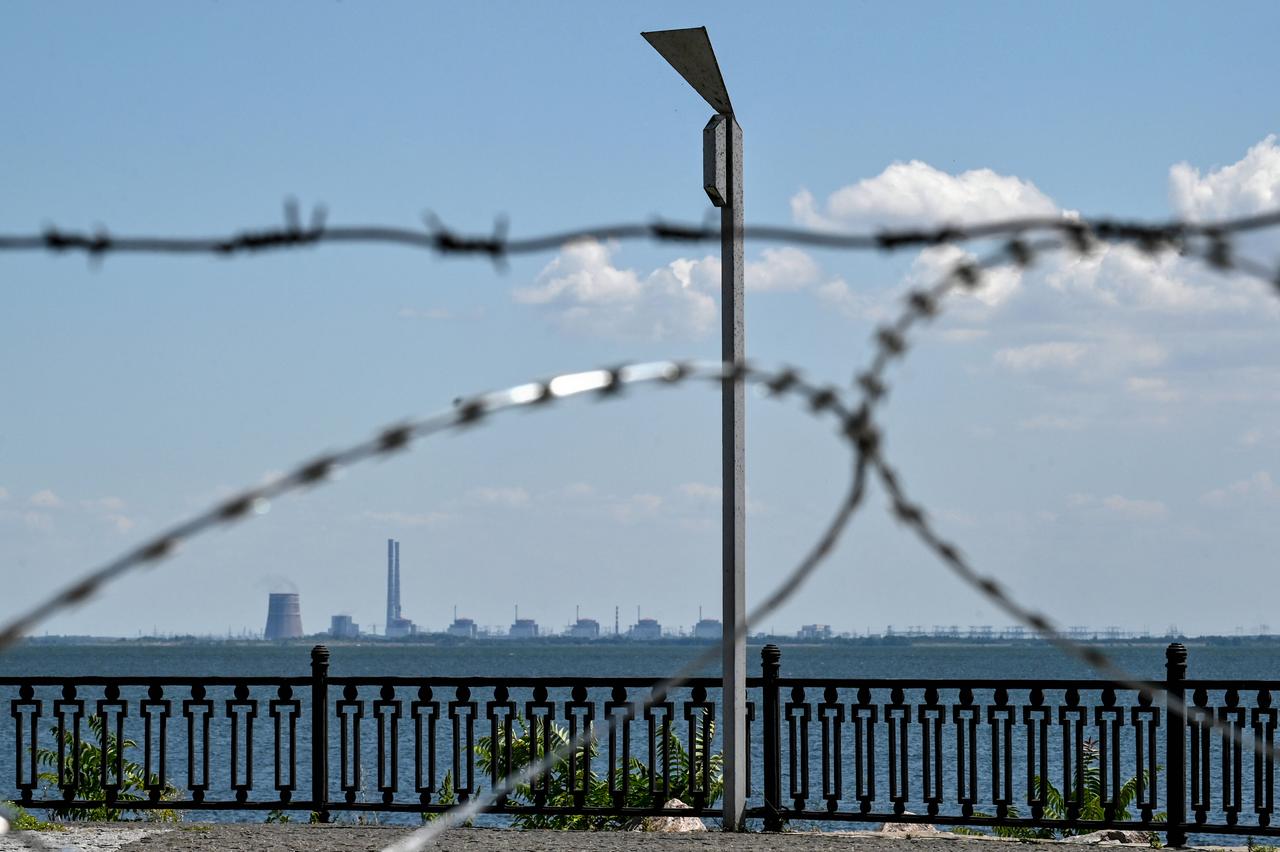 Blick auf das Atomkraftwerk Saporischschja durch Stacheldraht am Ufer von Nikopol. Russland beschießt Nikopol vom Gelände des Kernkraftwerks 