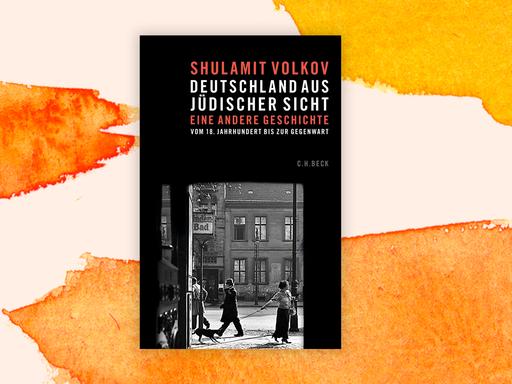 Cover des Buchs "Deutschland aus jüdischer Sicht" von Shulamit Volkov vor orangefarbenem Aquarellhintergrund: Das Cover zeigt unten ein Schwarzweißfoto einer historischen Straßenszene. Darüber stehen vor schwarzem Hintergrund in roten und weißen Großbuchstaben der Name der Autorin und der Buchtitel.