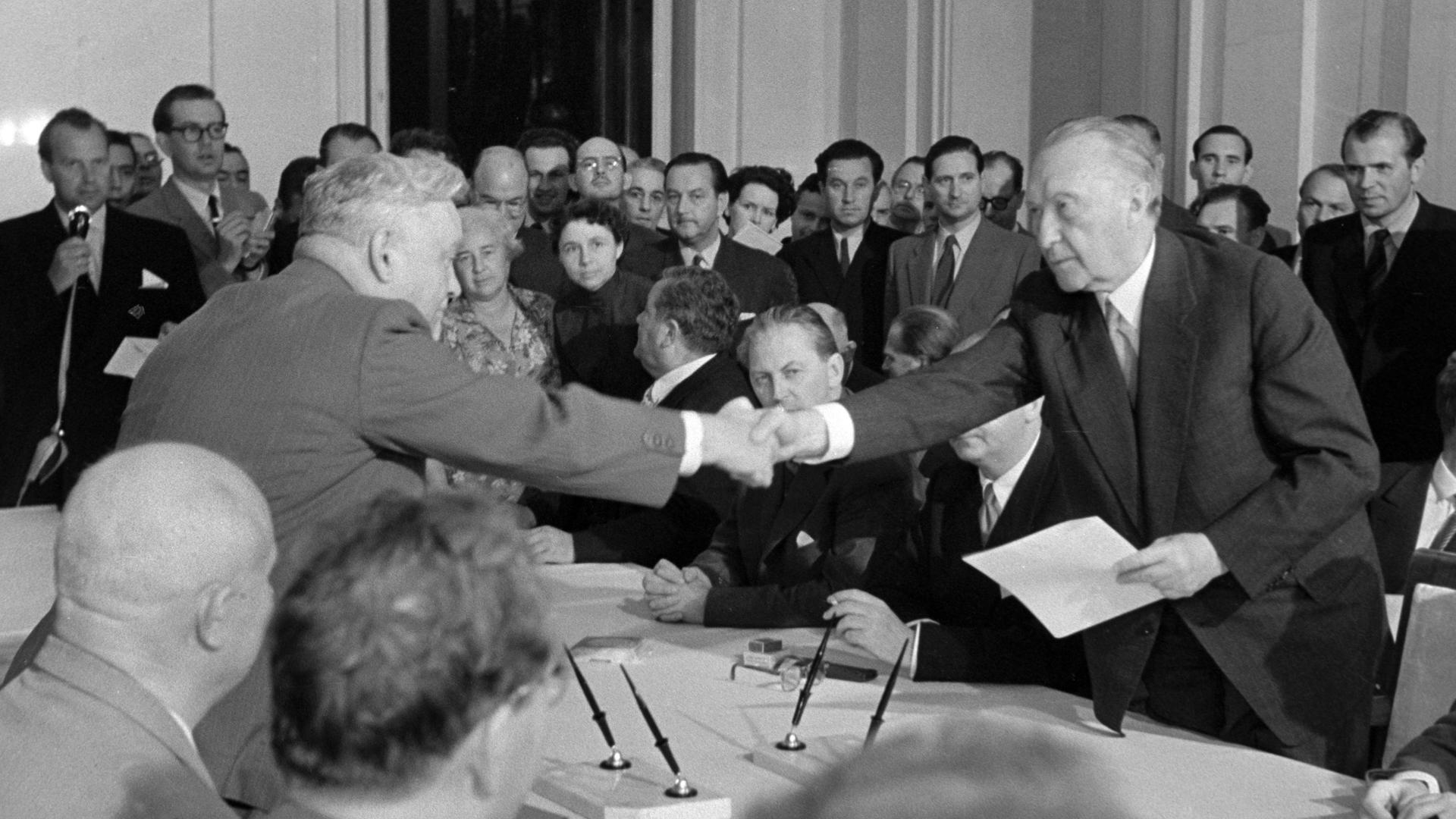 Der sowjetische Ministerpräsident Nikolai Bulganin (li) und der deutsche Bundeskanzler und Bundesaußenminister Konrad Adenauer (re) reichen sich nach erfolgreicher Vertragsunterzeichnung am 13.09.1955 in Moskau die Hand. Der sowjetische Ministerpräsident Nikolai Bulganin (li) und der deutsche Bundeskanzler und Bundesaußenminister Konrad Adenauer (re) reichen sich nach erfolgreicher Vertragsunterzeichnung am 13.09.1955 in Moskau die Hand.