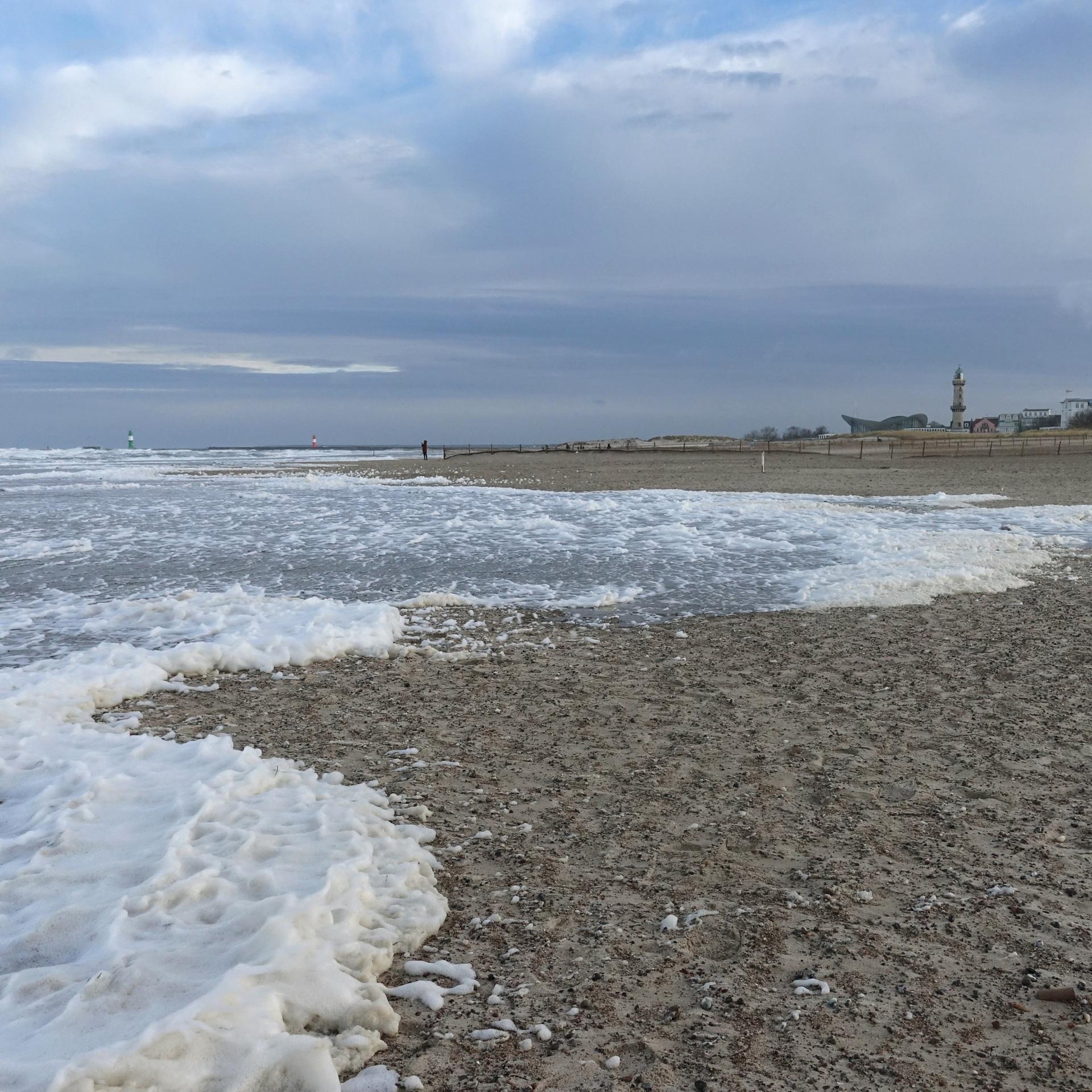Algenschaum am Strand der stürmischen Ostsee in Mecklenburg-Vorpommern. 