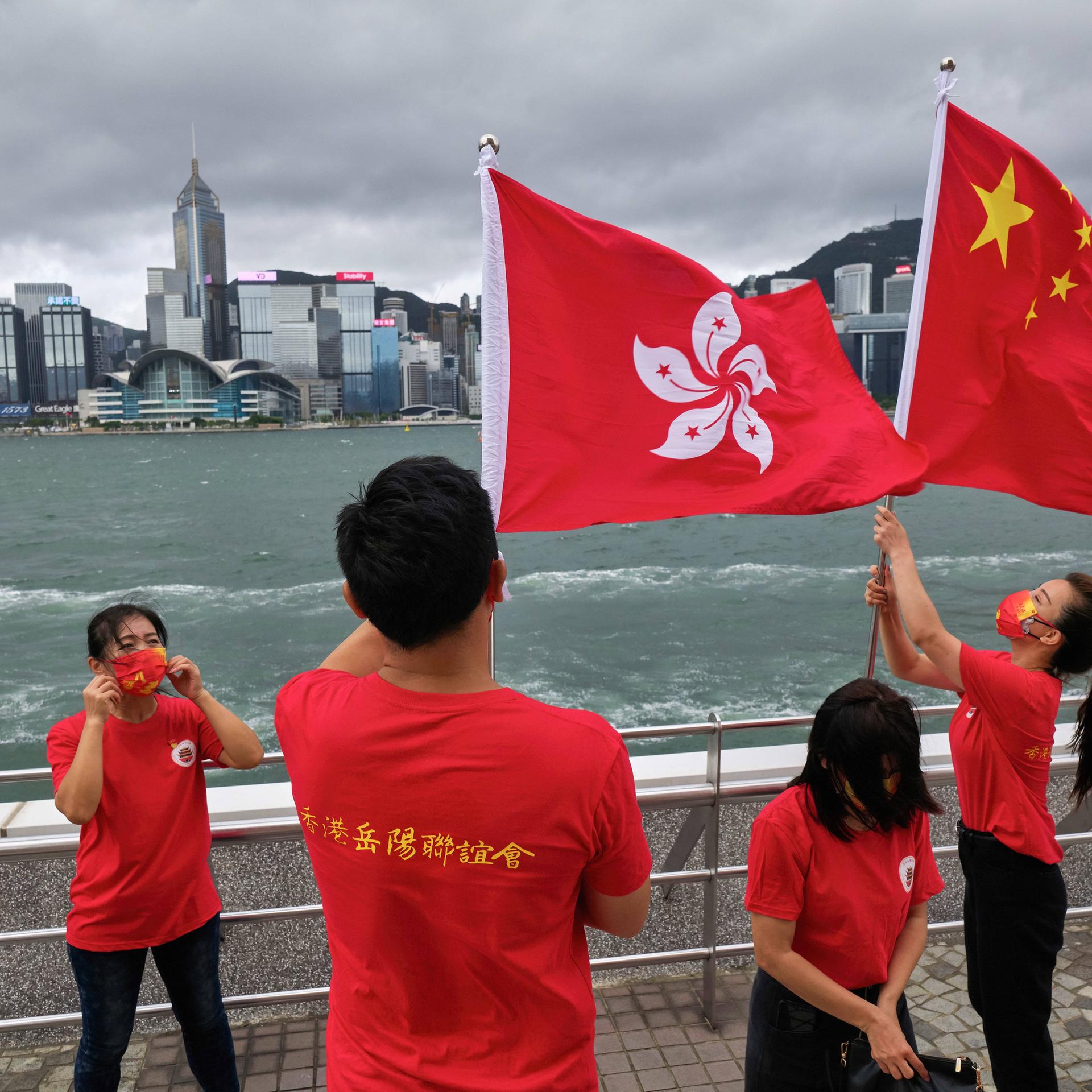 Menschen machen Fotos mit chinesischen und Hongkong-Flaggen vor der Bucht von Hongkong während der Jubiläumsfeierlichkeiten. 